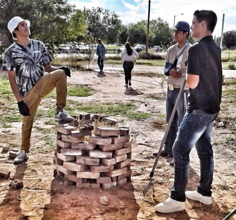 Las Cruces Student Posing With Biochar Brick Pit